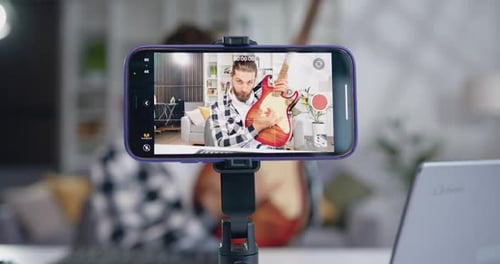 Man Records Himself Playing Guitar on Phone