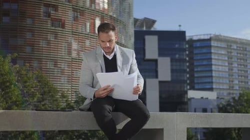 Focused Businessman Looking Graphs on Documents at City Street. Serious Business Man