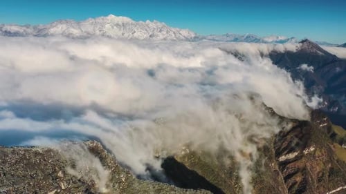 Aerial View of Clouds Flowing over Mountain Peaks