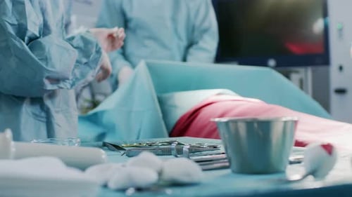 Close-up Shot in the Operating Room of Surgical Table with Instruments, Assistant Hands out Instrum