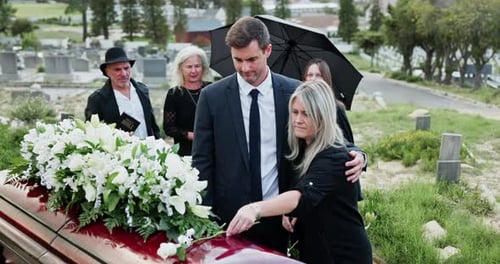 Man, hug and old woman at graveyard for funeral, burial service and mourning loss