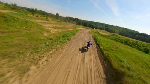 Dirt Bike Rider Racing on Rural Terrain