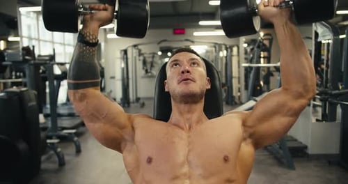 Muscular Man Lifting Weights in Gym