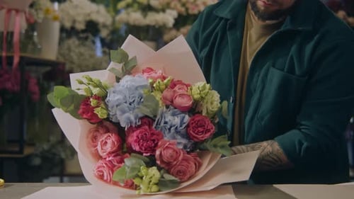 Man Arranging Colorful Flowers in Flower Shop