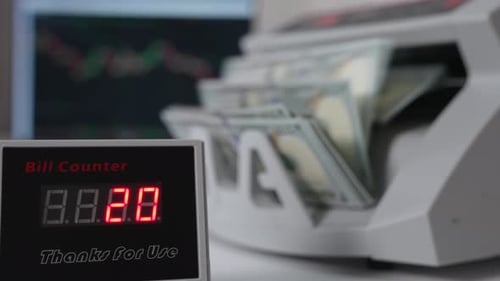 Bill counter showing quickly changing numbers of money counted.