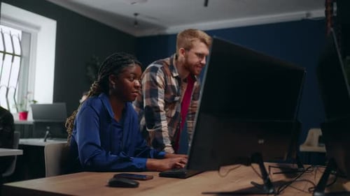 Schwarze Designerin und männlicher Ingenieur erstellen ein Projekt für ein multiethnisches Computerteam im Büro