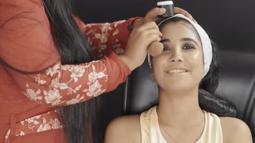 Young Woman Getting Makeup Applied with Brush