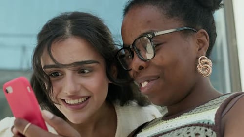 Two Young Women Looking at a Smart Phone