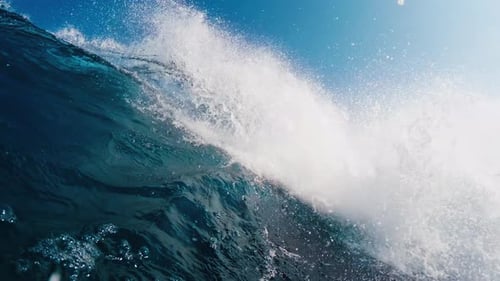 Underwater view of the rolling and breaking ocean wave and crystal clear water in Maldives