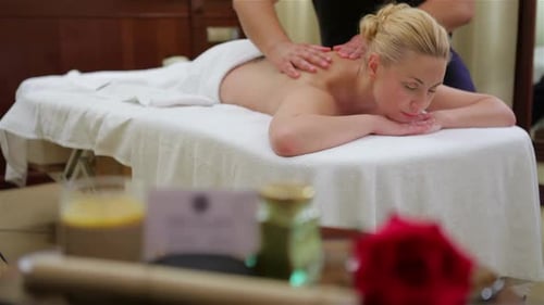 Frau erhält Rückenmassage im Salon Spa