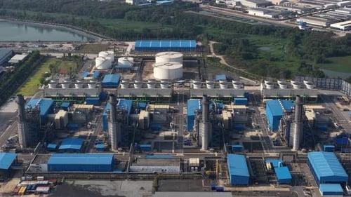 High aerial view of a sprawling industrial facility, showcasing the intricate network of pipes,