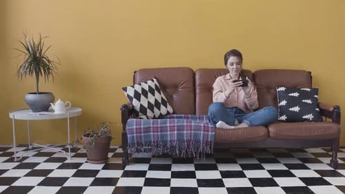 Woman Relaxing at Home with Smartphone