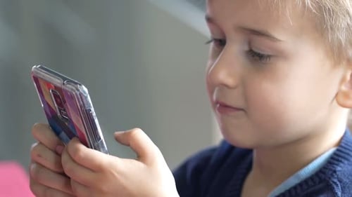 Young Boy Focused on Playing a Mobile Game