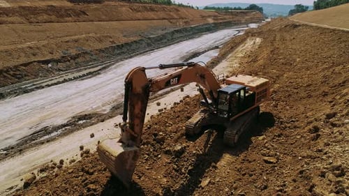 Excavator Moves Dirt on Construction Site, Aerial View
