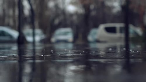 Heavy Rain Falling on Wet Asphalt in a Blurred City Parking Lot