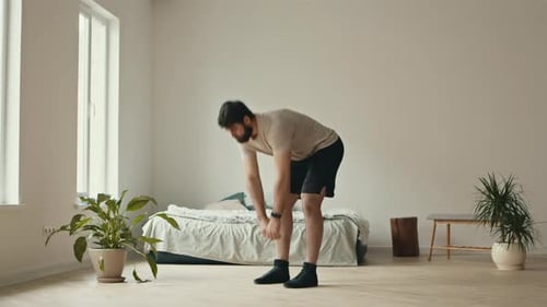 Man Doing Toe Touches for Exercise at Home