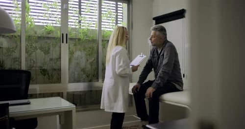 Doctor Talking to Patient in Office Exam Room