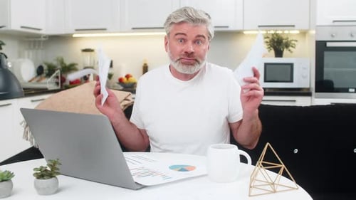 Worried Man Analyzes Data at Desk in Modern Home