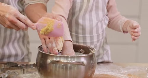 Woman and Child Baking Cookies Together in Kitchen