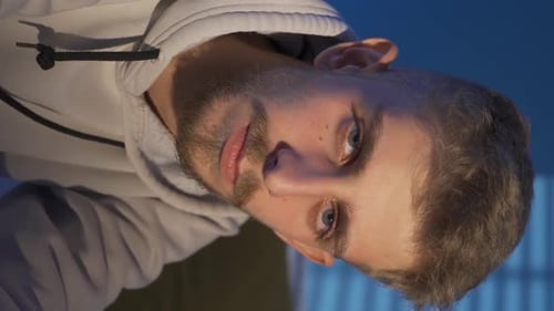 Vertical Video Of Close-up portrait of thoughtful and sad young man at home.