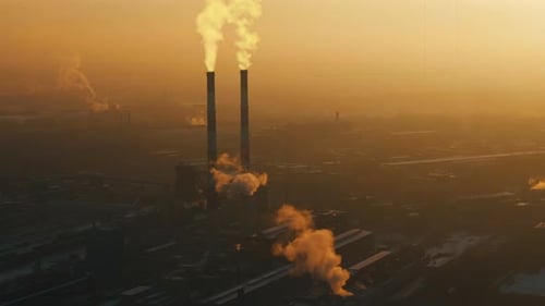 Industrial Smokestacks Releasing Smoke at Golden Hour