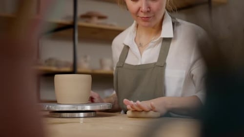Woman Smoothing Clay in Ceramics Workshop