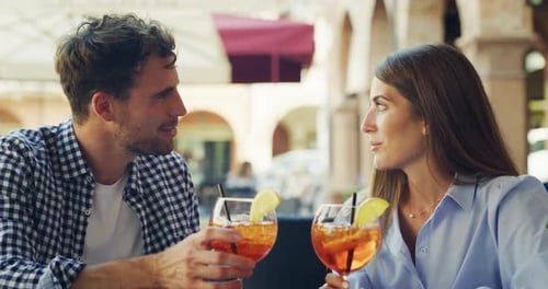 Happy Couple Clinking Drinks at Outdoor Cafe