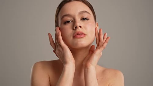 Young Woman Posing at Camera Playfully Smiling Touching Smooth Skin Close Shot Isolated on White
