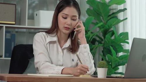 Woman Talking on the Phone and Writing Notes