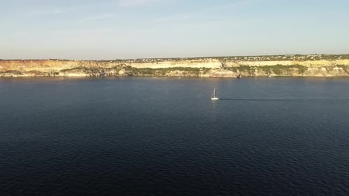 Aerial View of a Luxury Sailing Ship with White Sails in the Sea in the Evening Sunlight Luxurious
