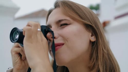 Attractive woman taking pictures outdoors with camera