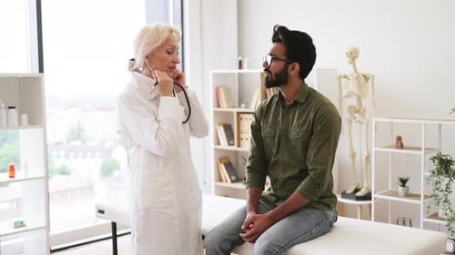Doctor Examines Young Man with Stethoscope in Clinic