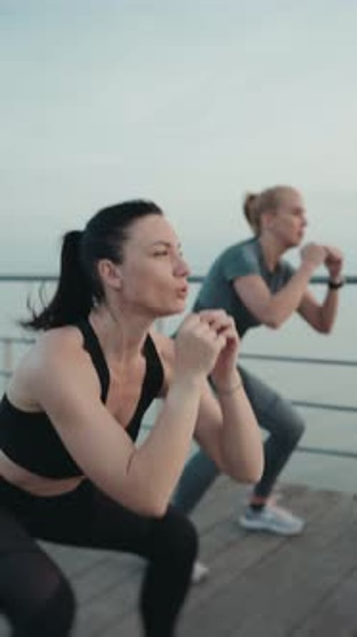 Women Exercising With Squats and Kicks by the Ocean