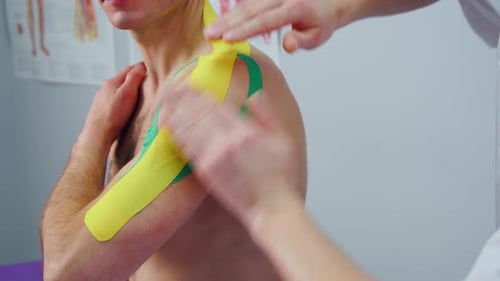 Applying Kinesiology Tape to a Patient's Arm
