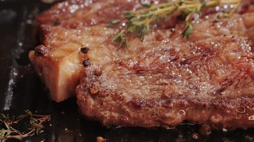 Fresh Marbled Beef with Pepper Salt and Rosemary Closeup Macro Cooking Juicy Steak on Grill with Oil