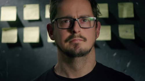 Contemplative Man with Glasses Looking at Notes