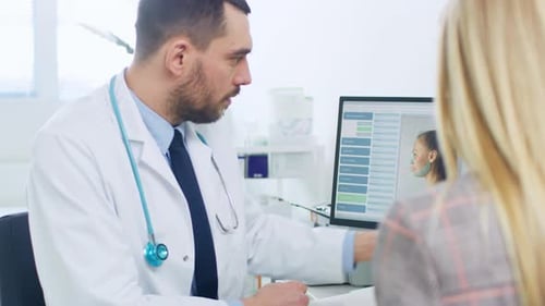 Plastic / Cosmetic Surgeon Consults Woman about Facial Lift Surgery, He Points at Computer Screen S