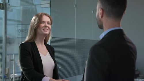 Business Woman Smiling and Shaking Hands with Colleague