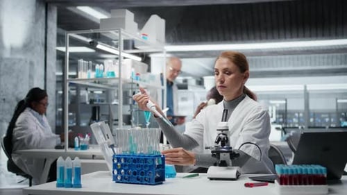 Un chercheur pipette un réactif dans une solution bleue pour l'analyse de la pureté