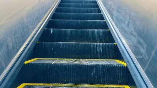 Empty moving escalator steps close up view. Low angle view of metal escalator steps moving