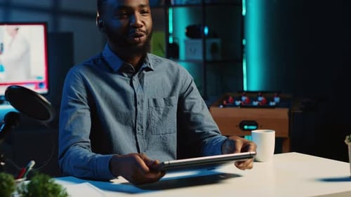 Adult Showing Laptop in Blue Lit Room