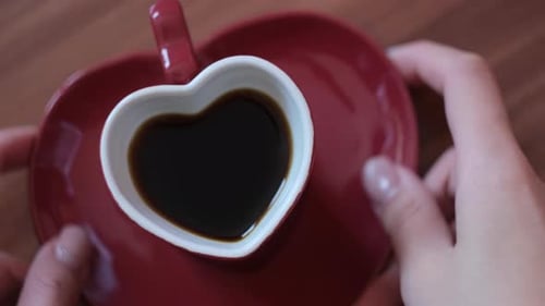 Close up top down view of woman hands taking small cup and plate of coffee from the table. Concept.