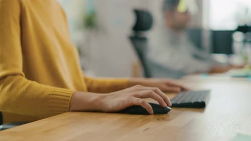 Anonymous Young Woman Sitting at Her Desk Using Laptop Computer. Focus on Hands Typing on Keyboard.