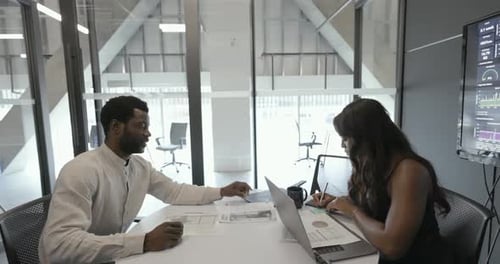 Business People Reviewing Paperwork In Conference Room Meeting
