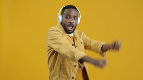 Man Dancing with Headphones on Yellow Background