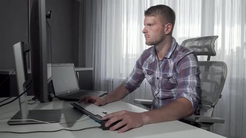 Konzentrierter IT-Experte, der in Dualscreen-Projektarbeit eintaucht