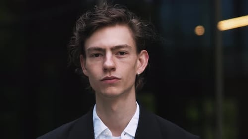 Close Up Portrait of a Happy Young Adult Male Businessman with Curly Hair and Brown Eyes Posing for