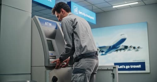 Techniker, der Geldautomaten im modernen Flughafenterminal wartet