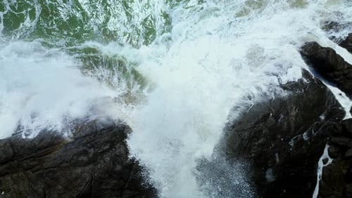 Top View Aerial of Waves Crashing on Rocks in a Blue Ocean Sea Waves on a Beautiful Beach Aerial