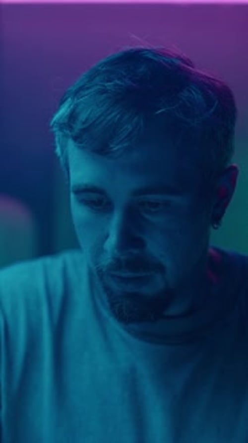 Man Puts on VR Headset Under Neon Lighting